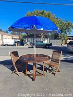 Full set: table, two chairs and blue umbrella on street