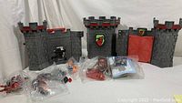 Full view of castle walls and components with several unopened figure/accessory bags and instruction sheet
