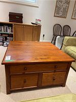 Front view of square coffee table showing three drawers and knob hardware