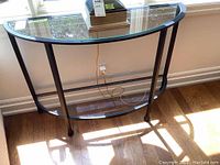 Front view of half-moon table showing metal frame and glass top