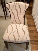 Front view close-up of one chair showing upholstery pattern and wood frame