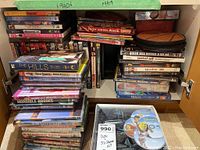 Photo showing stacked DVDs including titles such as Monsters Inc., The Hills series, Dickie Roberts, Horrible Bosses, and others.