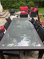 Front perspective of full table showing PVC woven frame and glass surface