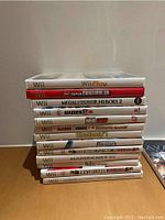 Stack of 14 Nintendo Wii game cases showing titles on the spines.