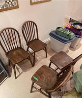 Four wooden chairs grouped together showing general condition and design