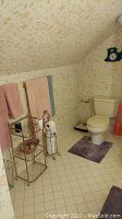 Full bathroom corner view showing toilet, purple rug, towel racks, a metal rack with multiple storage levels, hamper, toilet brush, and small wall clock