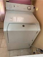 Front view of white Maytag electric dryer, model MDG7757AWW, showing front door and control panel placement.