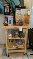 Full view of shelving unit with insect killer, coin bank, glass containers, and more household items