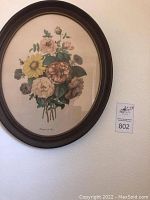 Oval framed floral art print titled "Bouquet de Fleurs" with mix of colorful flowers and green leaves on a white background.