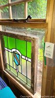 Overall view of stained glass panel hung in wood frame