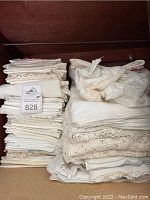 Photo of multiple stacks of folded vintage linens and doilies showing lace edges and crochet work