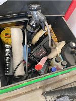 Photo showing Craftsman 6-inch polisher/sander with cord, replacement pads, paste wax, black spray bottle, and various small bottles of automotive fluids.