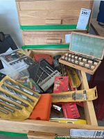 Photo showing the drawer of assorted drill bits, tool cases, level, and hardware bags.