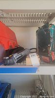 Dremel Multi-Max MM50 oscillating tool and Marita hammer drill with Makita bag on shelf.