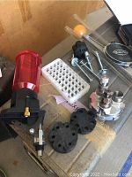 Photo of powder measure, black powder measure disks, priming tray, powder scale, and glass powder measure tubes with orange rubber bulbs.