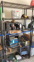 Front view of the entire adjustable metal shelving unit with items on shelves, which are not included in sale.