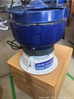 Photo showing the blue and white Quick N Ez Case Tumbler with label on the base.