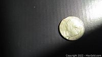 Photo of the front side of the 2014 quarter showing the minting errors and dents along the edges.