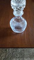 Top close-up view of the Courvoisier glass decanter showing the etched logo and stopper detail.