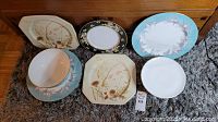 Photo showing assorted china dishes and plates in floral designs from Wedgwood, Mikasa, and Royal Albert.
