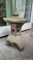 Front view of the complete pagoda showing the arched base and middle section with windows beneath the wide flared roof.