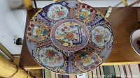 Full top view of the Imari ware plate showing central medallion and border details with floral and geometric decorations in multicolor and gold accents.