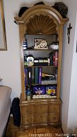 Full view of vintage Drexel shelf showing clam shell top, shelves with various items, and two bottom drawers