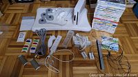 Main view of console, balance board, controller, cables, attachments, and game stack