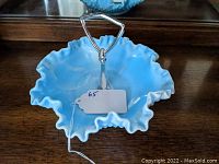 Top view of blue and white swirled hobnail milk glass bowl with metal handle in center