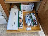 Drawer with Kenmore food sealer machine and boxes of vacuum sealing rolls plus a Handi-Vac freezer pump.