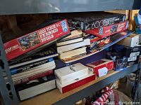 Shelf view showing a variety of boxed Star Trek puzzles, games, and books stacked together, some still sealed.