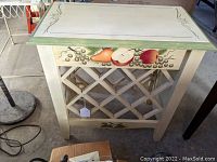 Front view of the wine bottle rack table showing fruit decoration and lattice rack