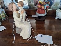 Front view of Willow Tree grandmother figurine holding baby, showing detailed carving and paint