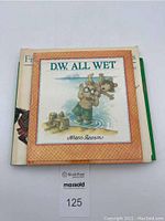 Top view of the lot showing D.W. All Wet hardcover on top with three other books stacked underneath.