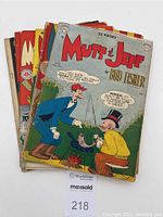 Six Mutt & Jeff comic books stacked, showing colorful front covers with cartoon illustrations, headlined by title 'Mutt & Jeff' by Bud Fisher, all showing signs of age and wear.