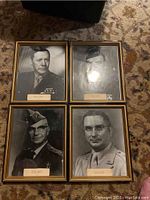 Four framed black and white military portraits arranged on carpet, showing back-to-back layout and frame condition