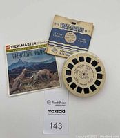 Three items: GAF View-Master reel model 946, paper sleeve "Prehistoric Animals," and package backing with lot number displayed.