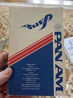 Handheld photo showing 1979 Pan Am Flight Attendant Union Agreement booklet front cover with white, blue, red design and text.