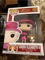 Front view of the boxed Funko Pop! figure showing Queen Elizabeth II in pink outfit with accompanying dog figure.