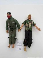 Full view of two G.I. Joe dolls side by side, showing their clothing and condition.