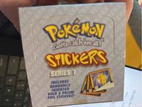 Front view of sealed Pokémon Stickers Series 1 box showing logo and collector details.