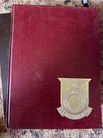 Maroon hardcover yearbook with gold USS Forrestal insignia on front.