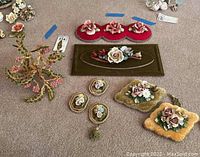 Top down photo showing all floral wall art pieces and floral wire sculpture arranged on carpet