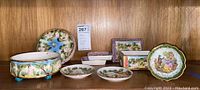 Full set of Italian china dishes and Limoges plate displayed on wood surface