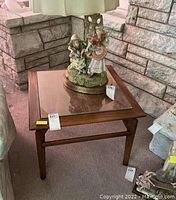 View of the full table showing proportions and the glass top with a decorative figurine on it.