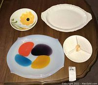 Four serving pieces displayed on wooden table showing all items for sale.