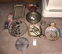 Overview of silver plate serving pieces including trays, platters, copper leaf dish, coasters, spoons, and metal polish.