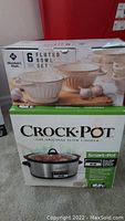 Boxed Crock Pot slow cooker with Smart-Pot label and Member's Mark 6-piece fluted bowl set box on top.