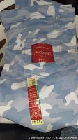 Blue and white camouflage pants with back pocket label and size tags