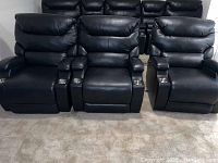 Three black theater recliners side by side showing overall layout and condition